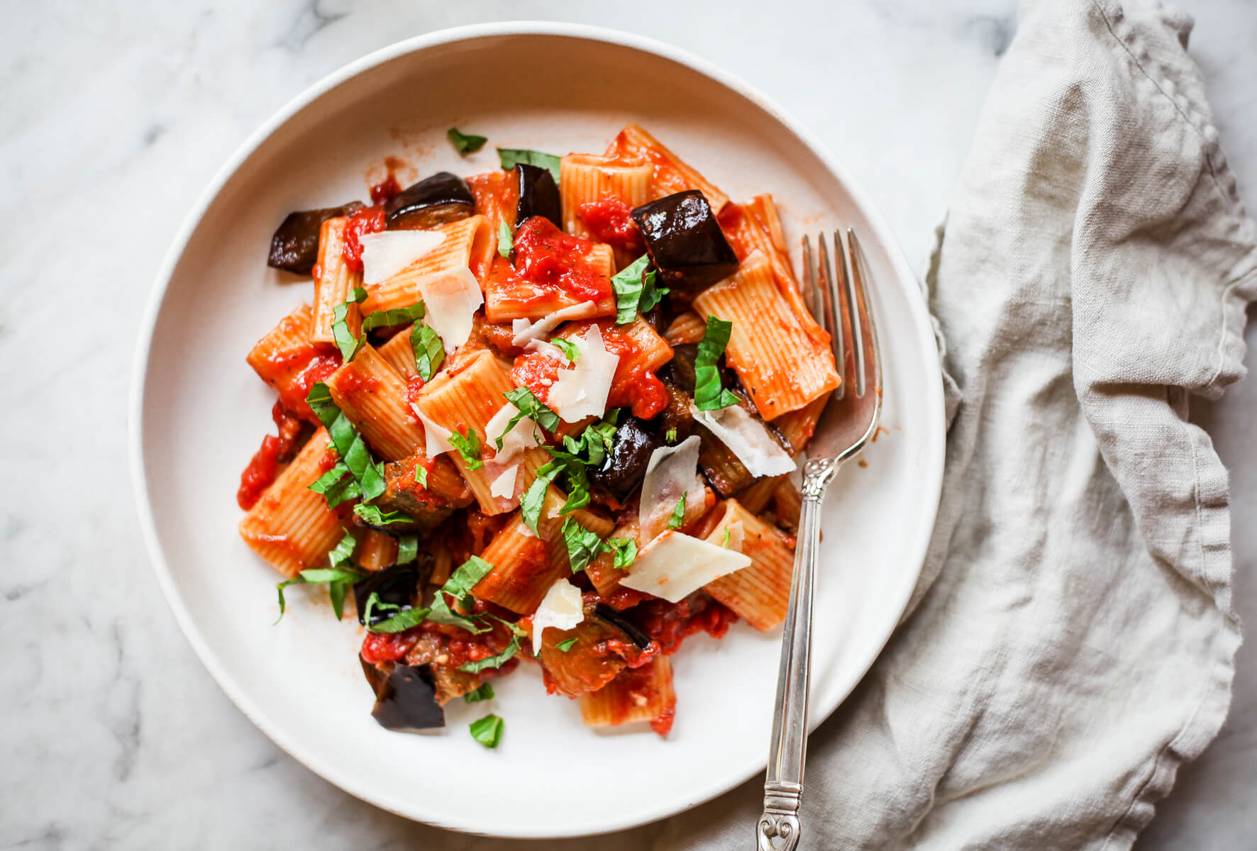 Pasta alla normal eggplant ragu on a white ceramic plate.