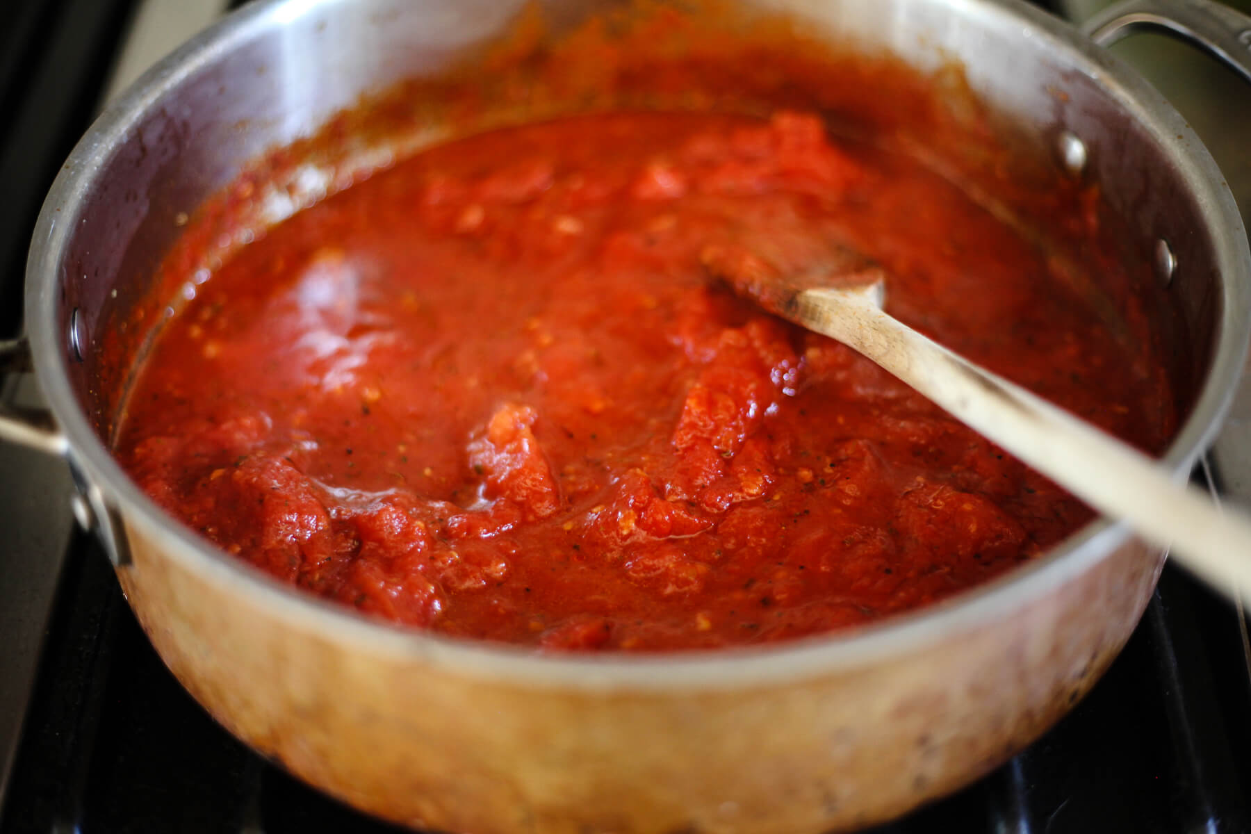 Tomato sauce for pasta alla norma simmers on the stove.