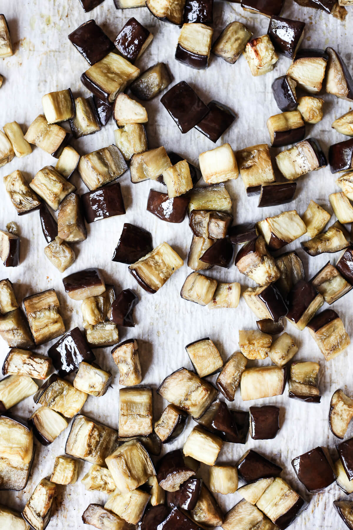 Baking Eggplant for Ragu Cubes of baked eggplant on a parchment-lined baking sheet. This roasted eggplant will be used for eggplant ragu.