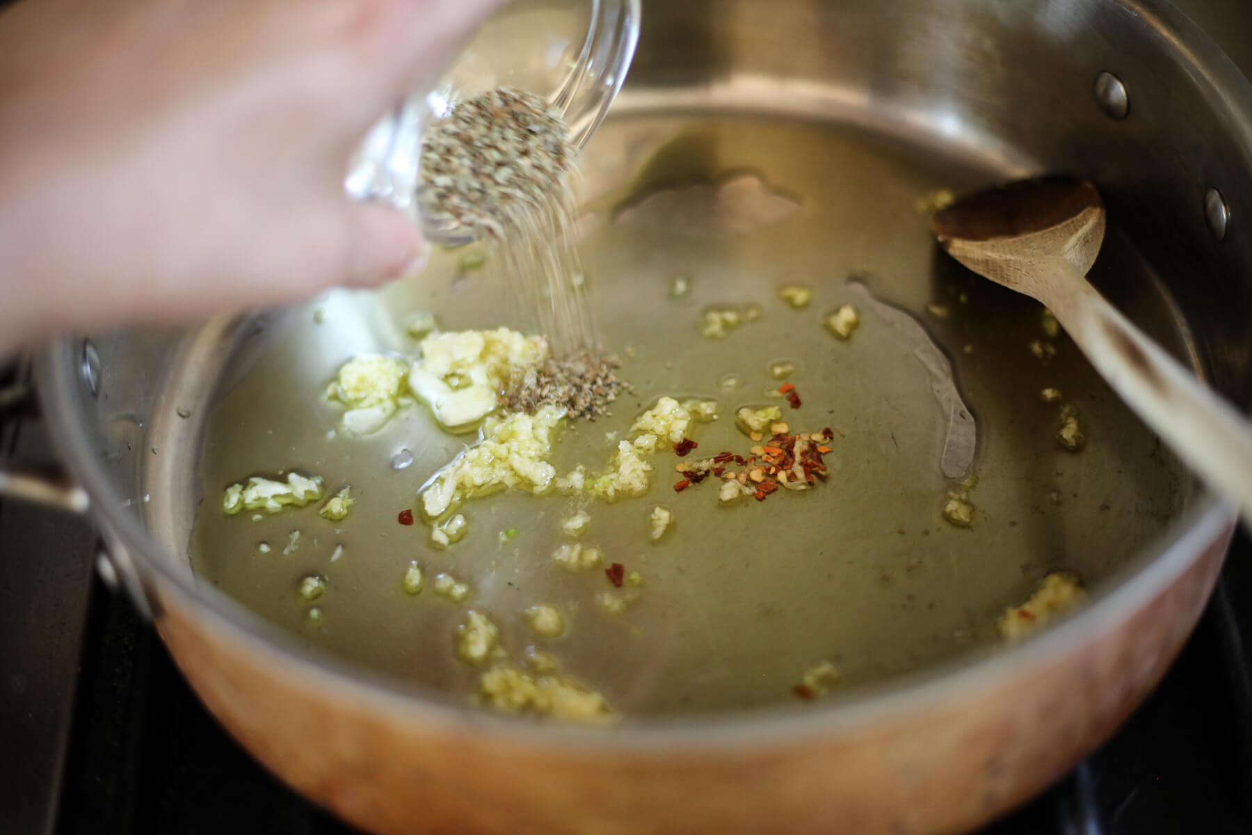 Garlic, red pepper flakes, and oregano in olive oil in a large skillet.