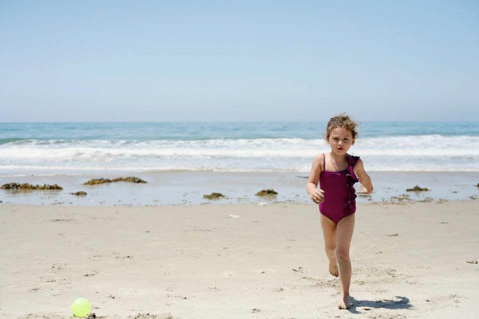 A young girl runs in front of the ocean at a beach in Santa Barbara. 