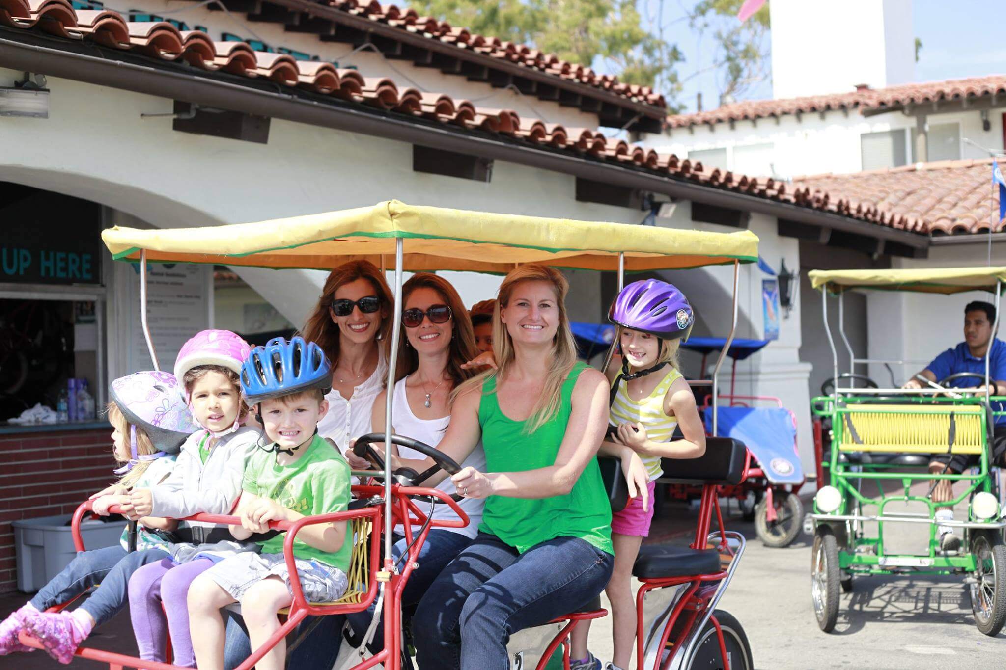 Three moms and a 5 young kids ride in a Surry that was rented at Wheel Fun Rentals in Santa Barbara. 