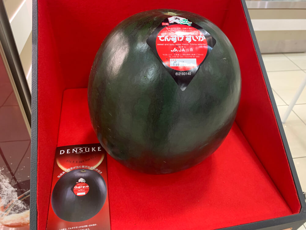 A black Densuke watermelon in a red case in Japan. 