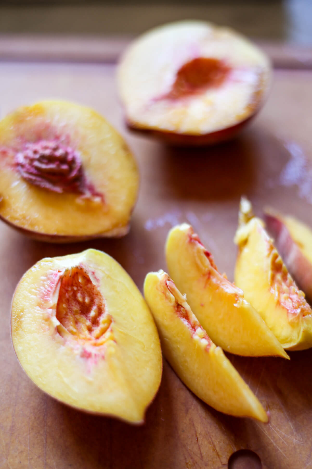 Peaches are cut in half and then sliced.