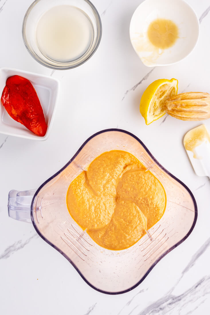 Homemade roasted red pepper hummus seen in a blender from above.