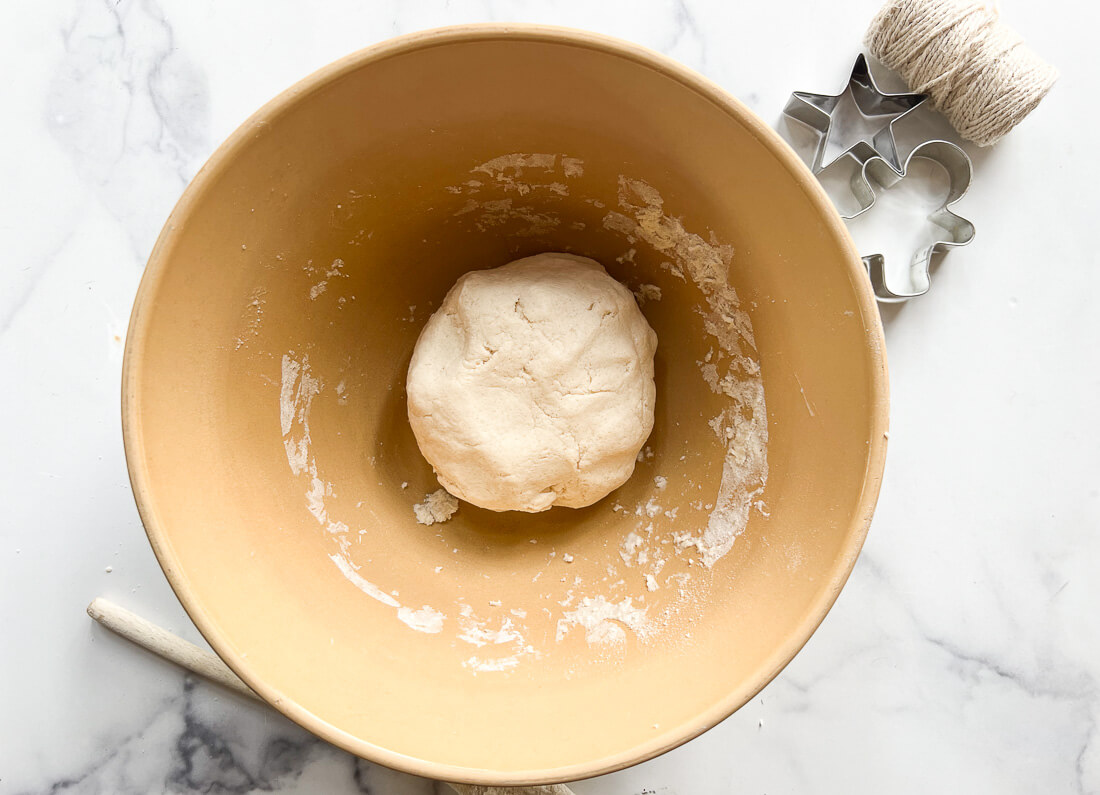 A smooth round ball of salt dough in a ceramic bowl.