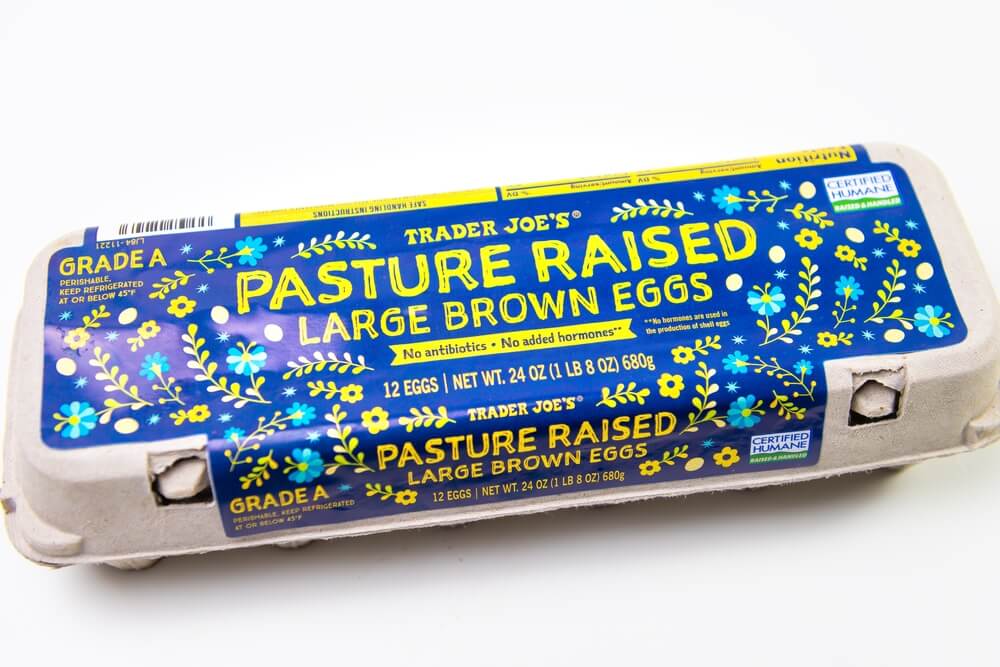 A carton of Trader Joe's Pasture Raised brown eggs. A Certified Humane label can be seen on the blue and yellow packaging. 