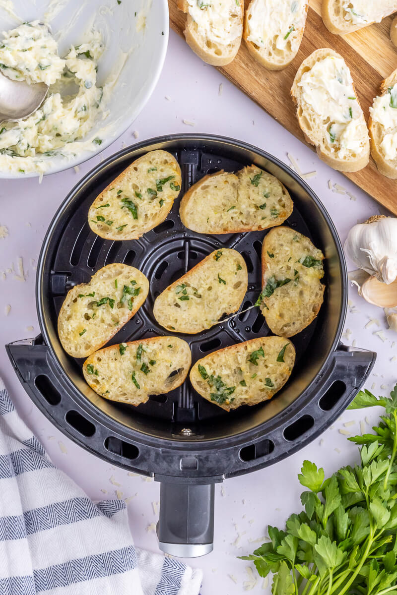 Perfectly crisp slices of garlic bread in an air fryer basket.