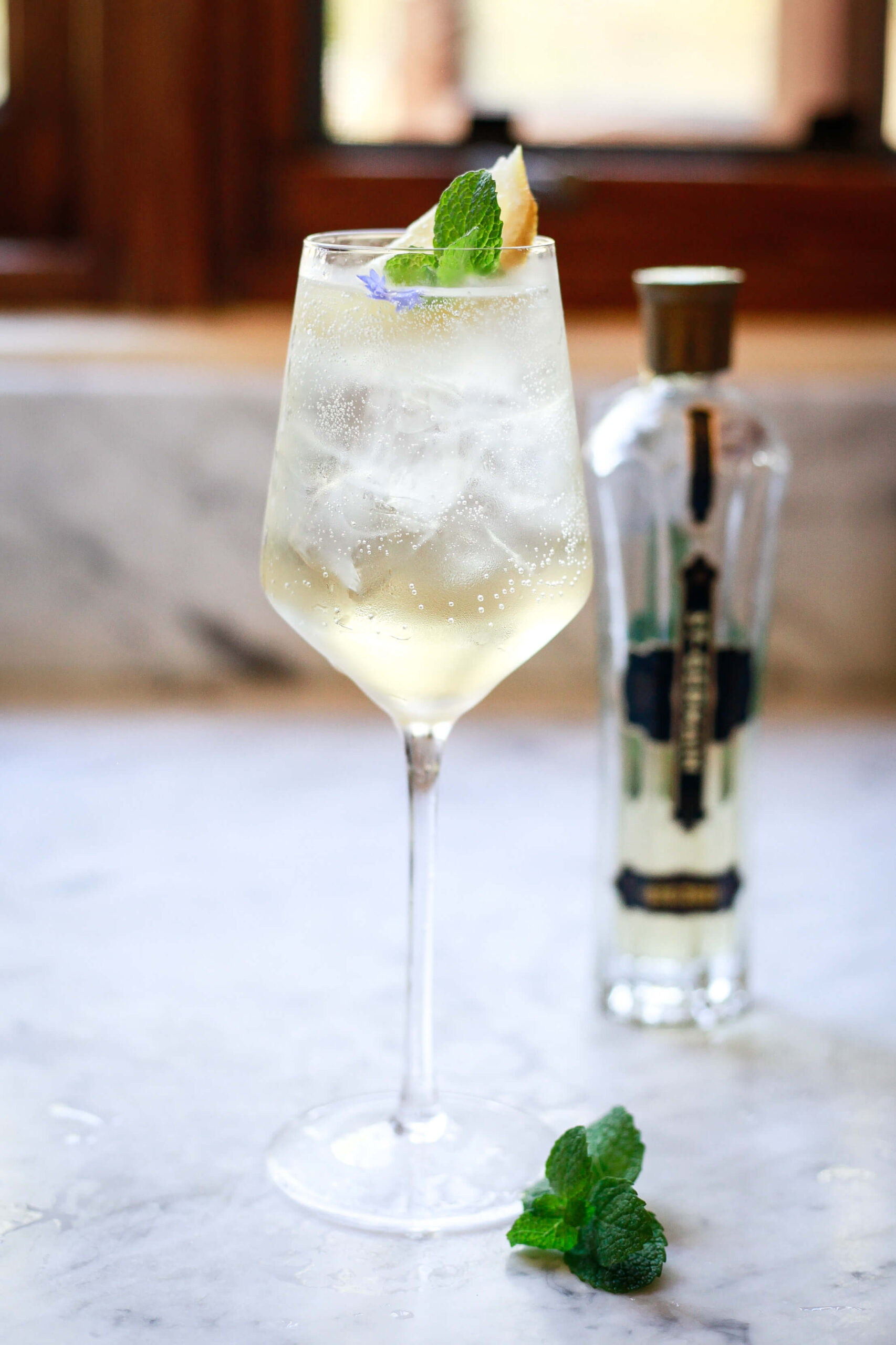 Hugo Spritz on a marble counter with St. Germain bottle in the background.