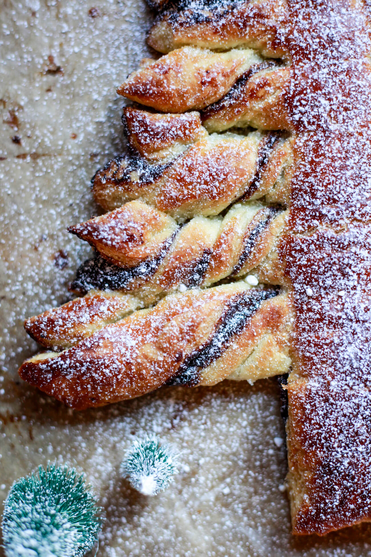 A close up photo of the branches of a Nutella Christmas tree made with puff pastry and dusted with powdered sugar. 