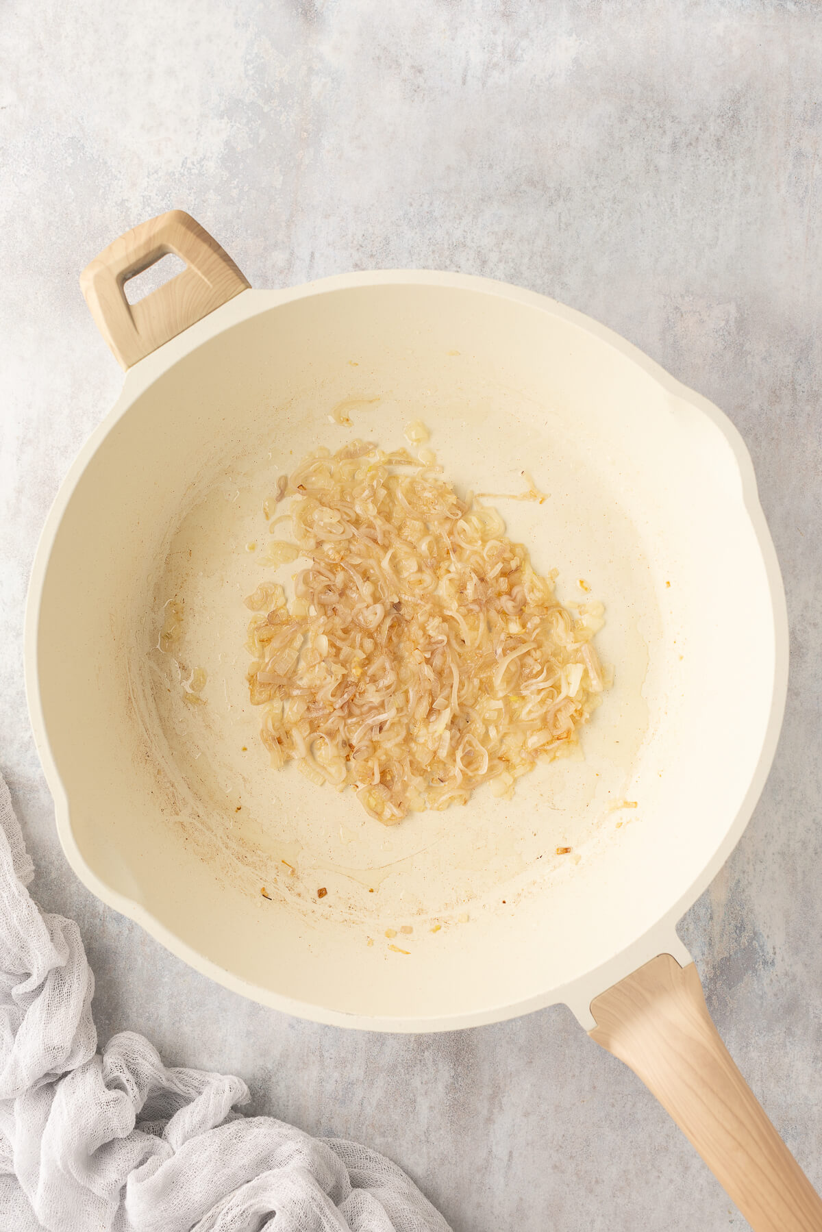 Shallots cooking in a ceramic pan.