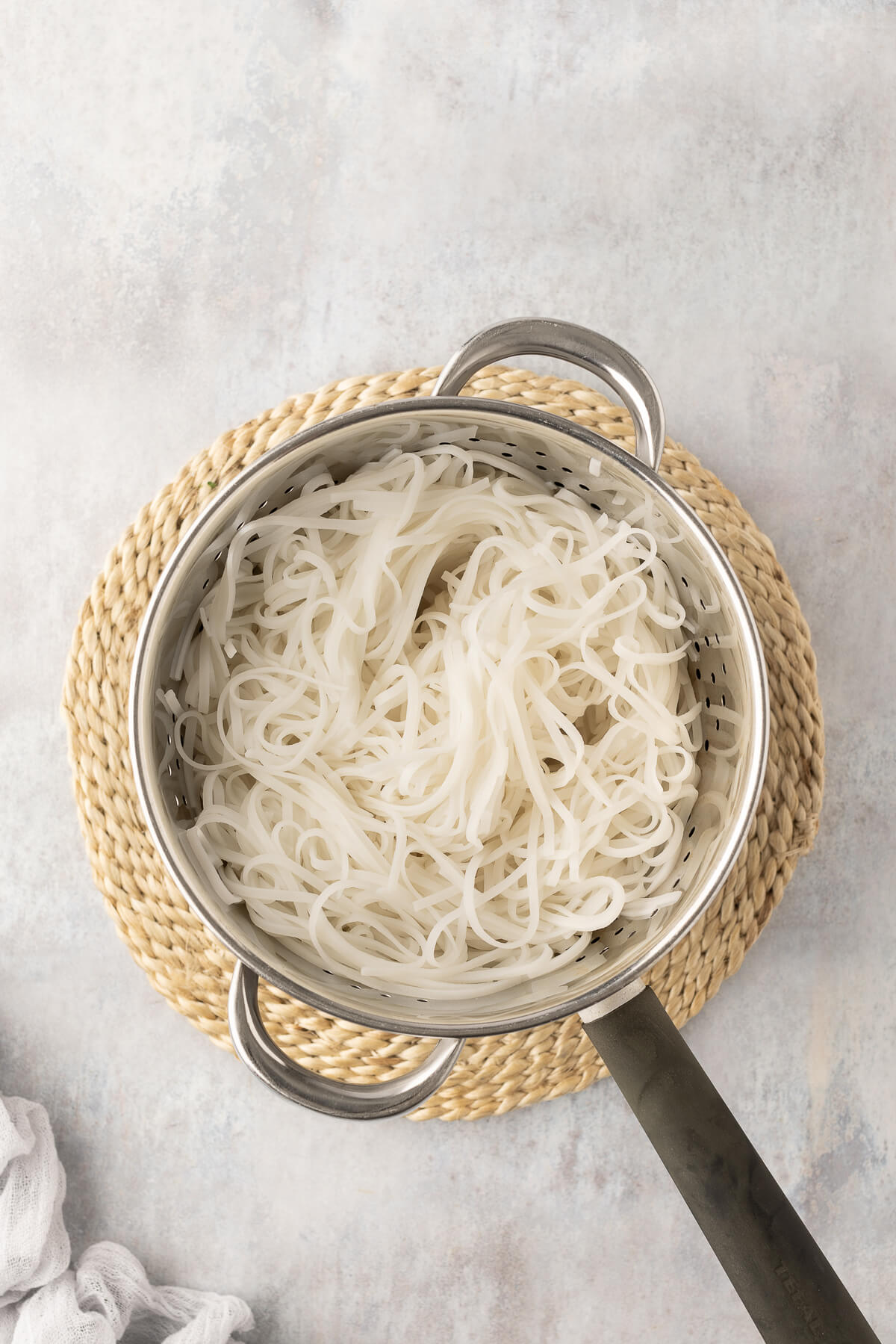 Cooked rice noodles are strained.