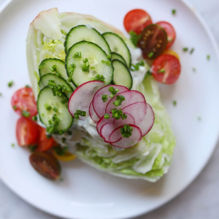 An overhead photo of a classic wedge salad made with iceberg lettuce and blue cheese dressing.