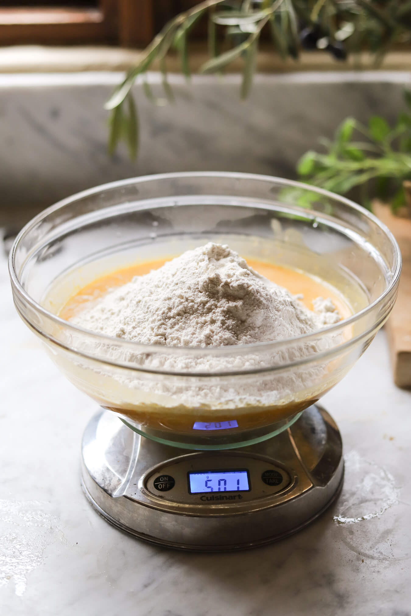 Mixing Pumpkin Sourdough Dough Mixing pumpkin sourdough dough ingredients in a glass bowl on a kitchen scale