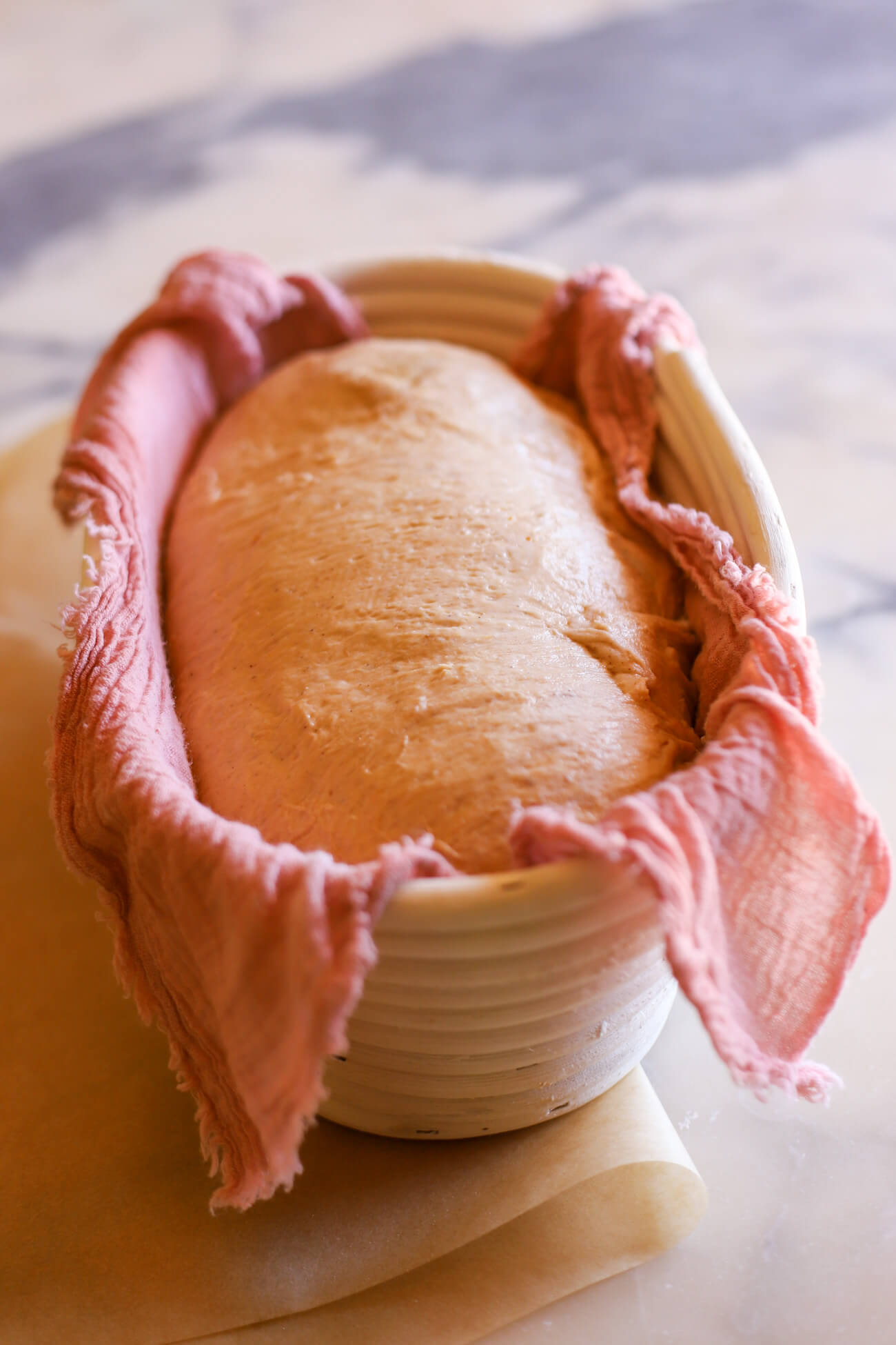 Pumpkin sourdough bread dough in a banneton for a second rise.