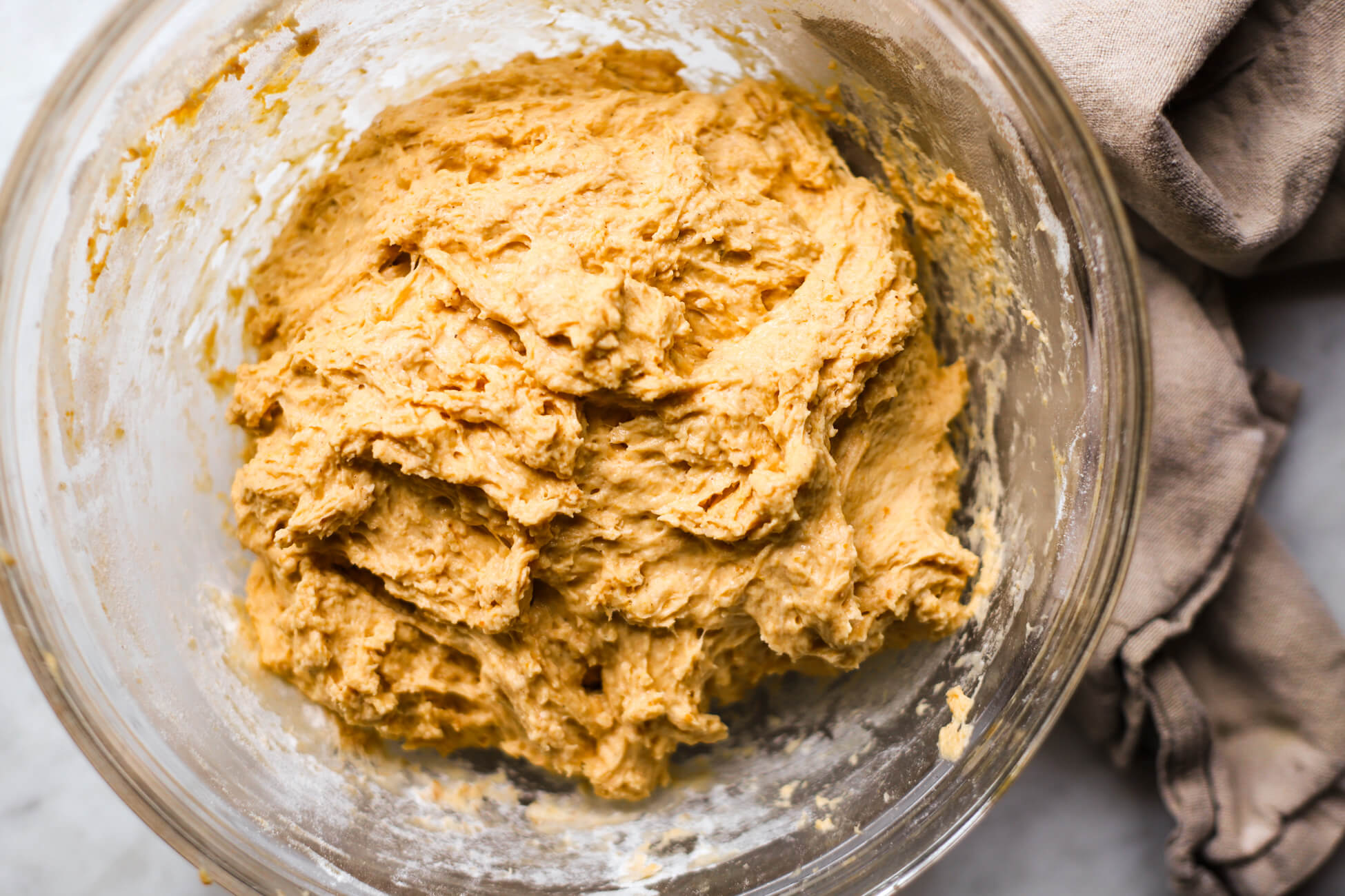 Pumpkin sourdough bread dough just mixed together in a glass bowl.