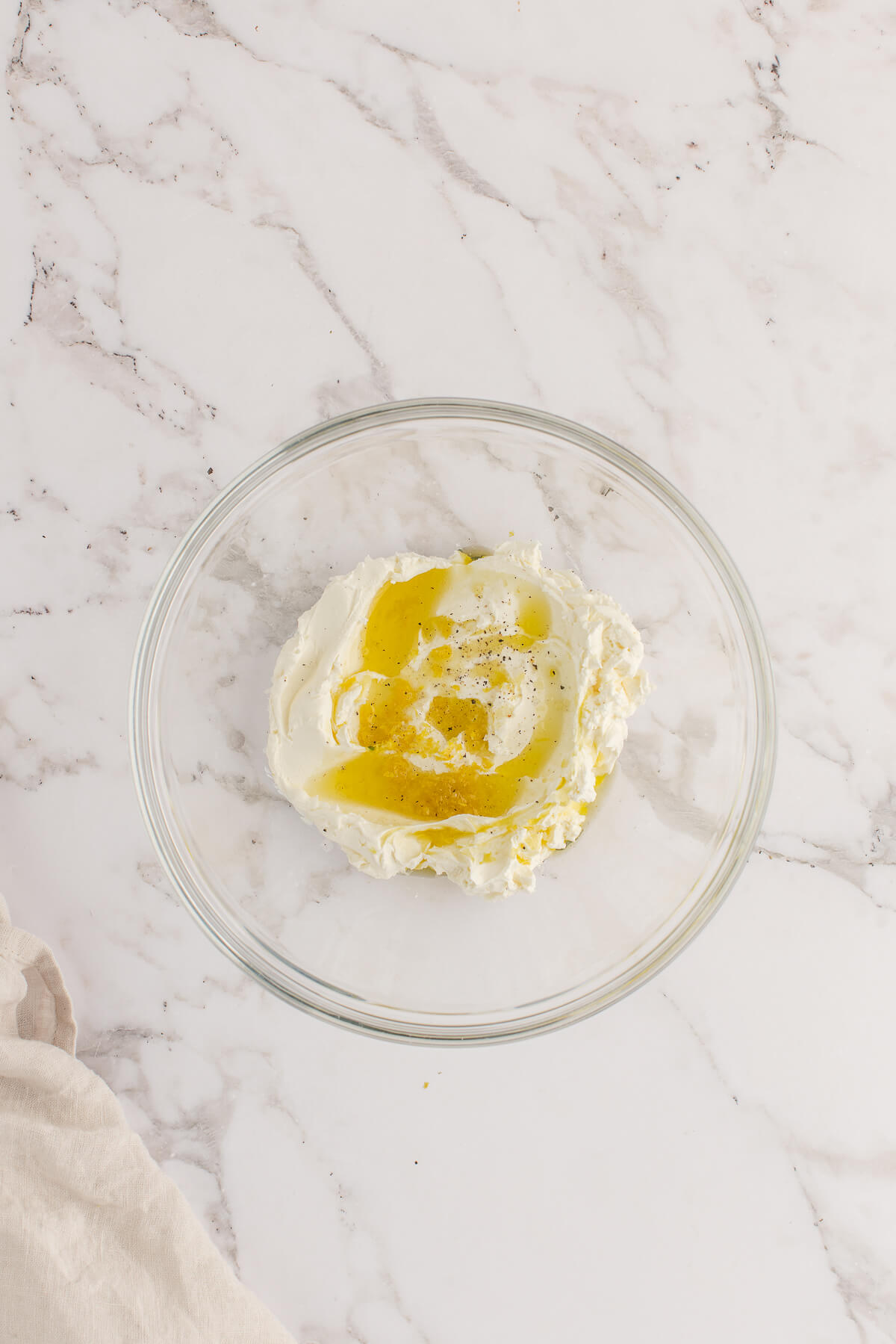 Whipped Ricotta Recipe Bowl of ricotta cheese drizzled with olive oil, lemon juice, salt, and pepper before whipping for crostini topping.