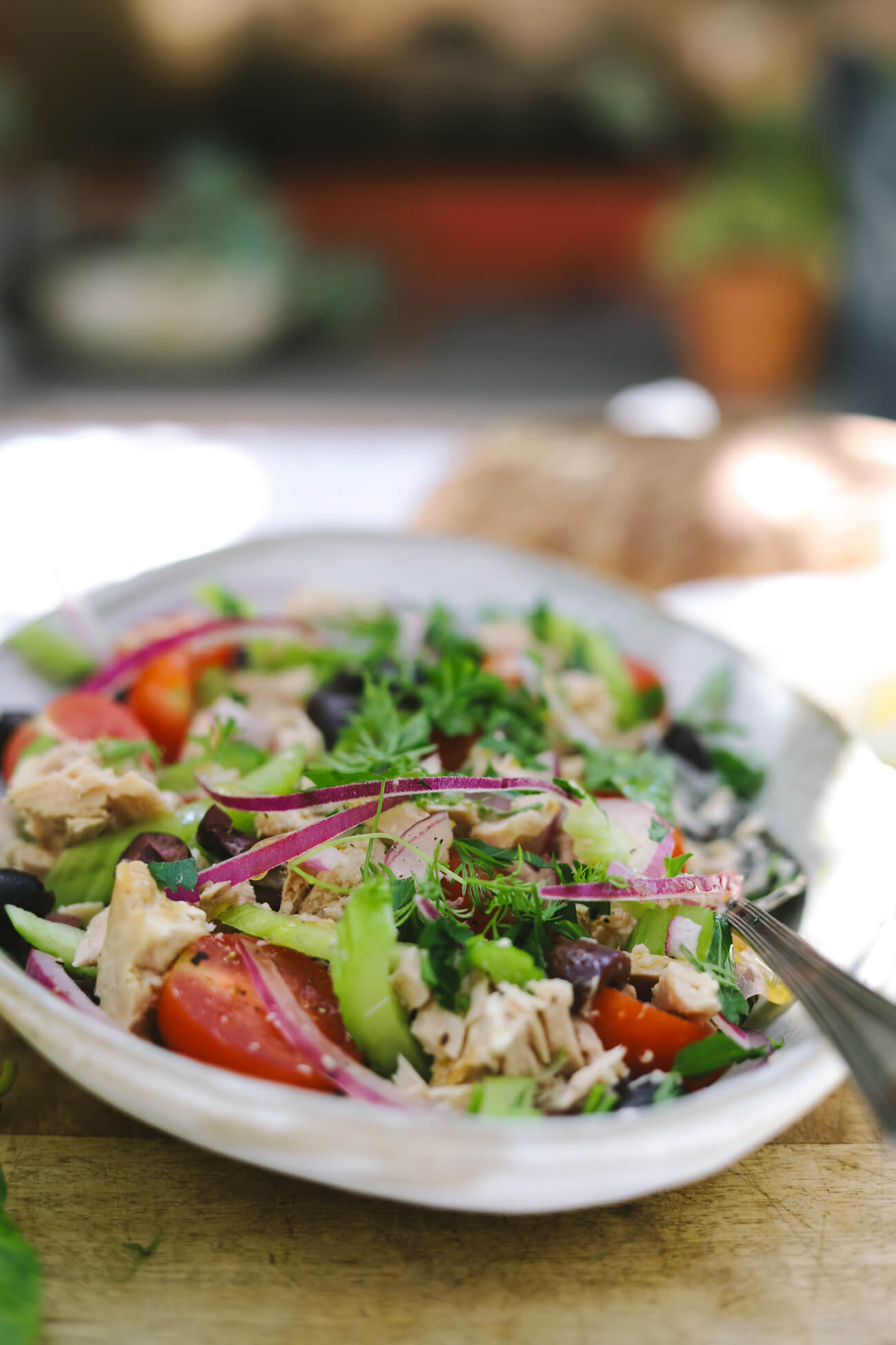 Mediterranean tuna salad Mediterranean tuna salad with albacore tuna, cherry tomatoes, celery, red onion, kalamata olives, and fresh parsley in a shallow bowl.