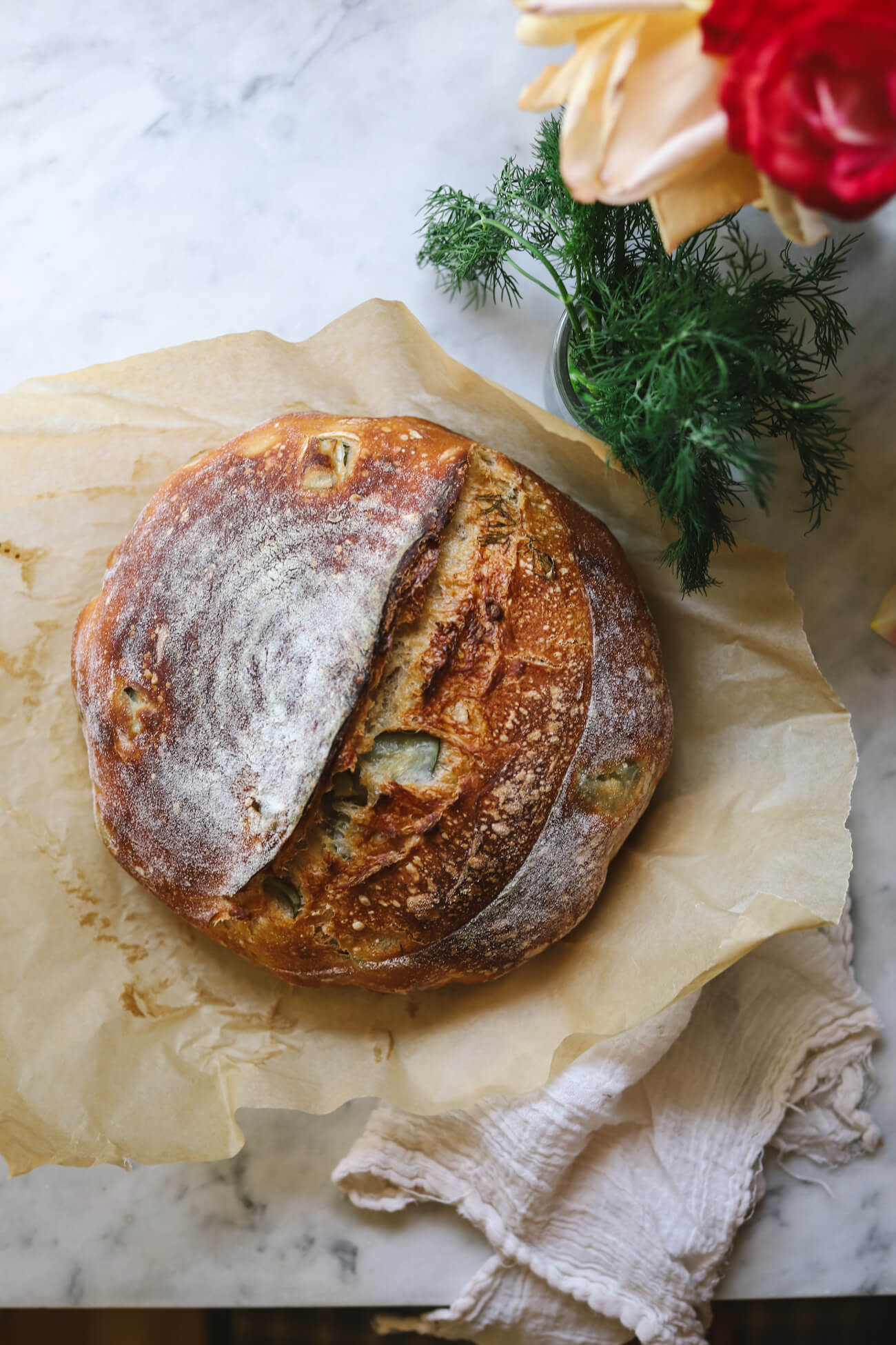 Dill Pickle Sourdough Bread Whole dill pickle sourdough bread loaf with visible pickle pieces and fresh dill