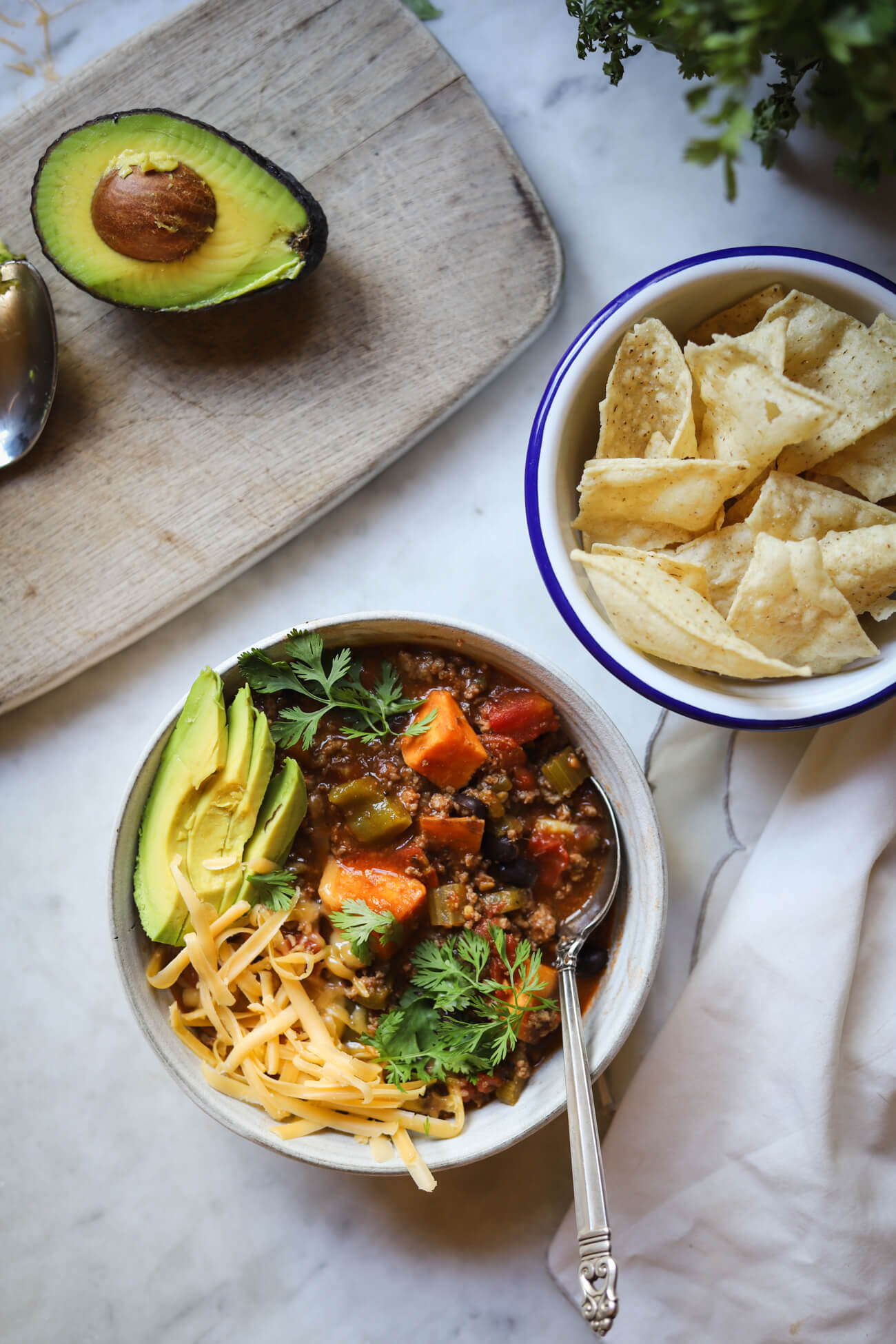 Low FODMAP Chili with Sweet Potatoes and Corn Chips Low FODMAP chili with ground beef, sweet potatoes, black beans, cheddar, avocado, cilantro, and corn tortilla chips