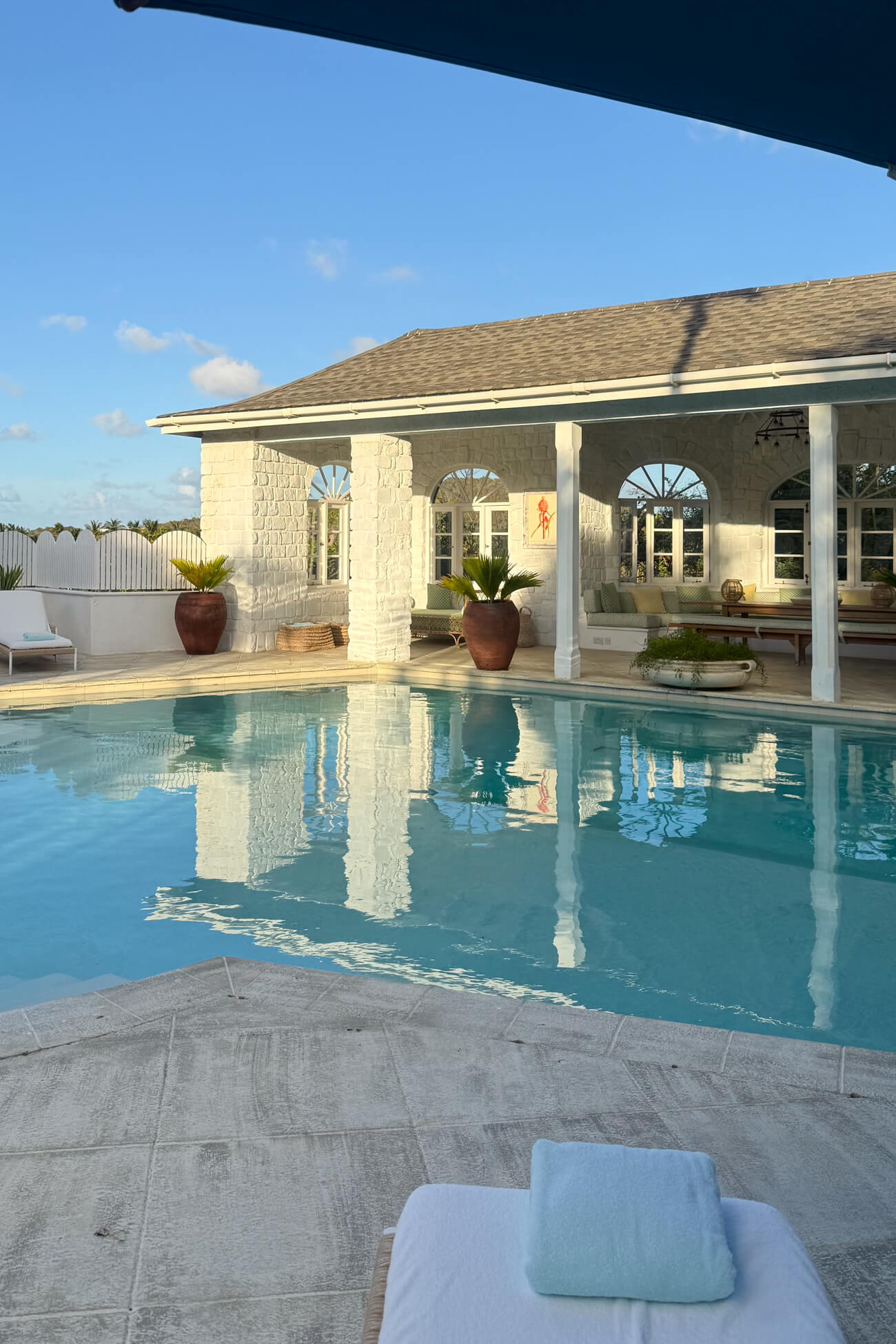 Cotton House Residence Swimming pool at The Residence at Cotton House on Mustique, surrounded by elegant Caribbean architecture and a covered open-air terrace.